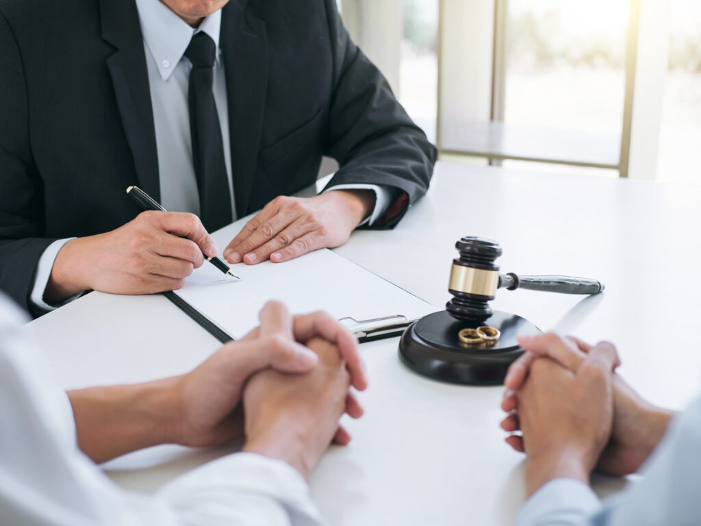 Agreement prepared by lawyer signing decree of divorce (dissolution or cancellation) of marriage, husband and wife during divorce process with male lawyer or counselor and signing of divorce contract.